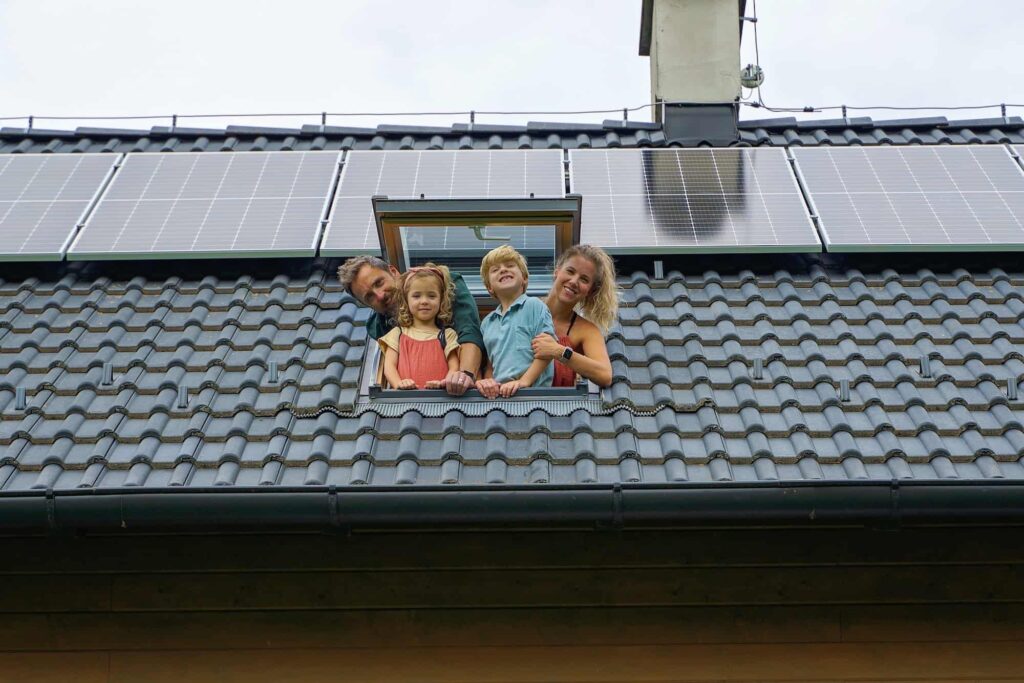 A happy family of four peeking out of the roof window